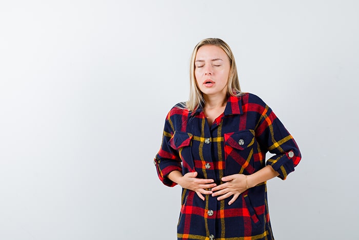 Patologías digestivas en navidad: young blonde woman having stomachache min - HeelEspaña